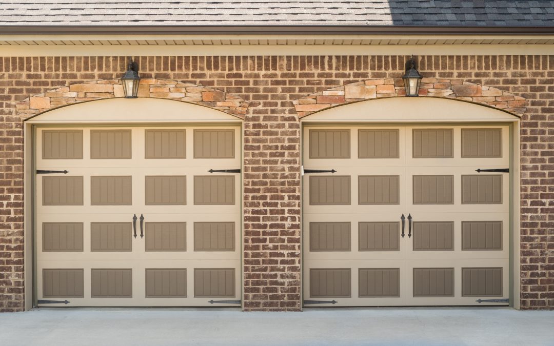 Exterior two door garage surrounded by brick and stone