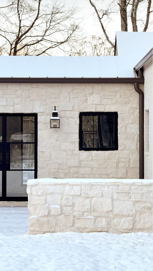snow on light beige color stone veneer exterior