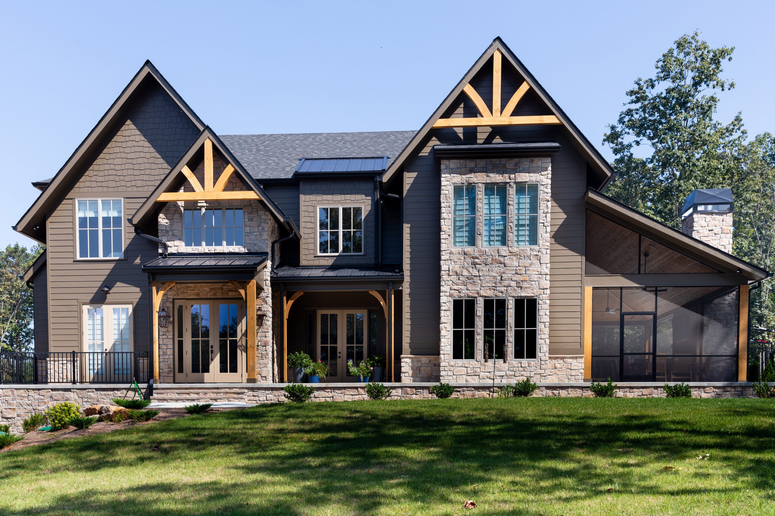 Stunning two-story home with brown siding paired with natural stone from the 19th Century Stone collection at Horizon Stone.