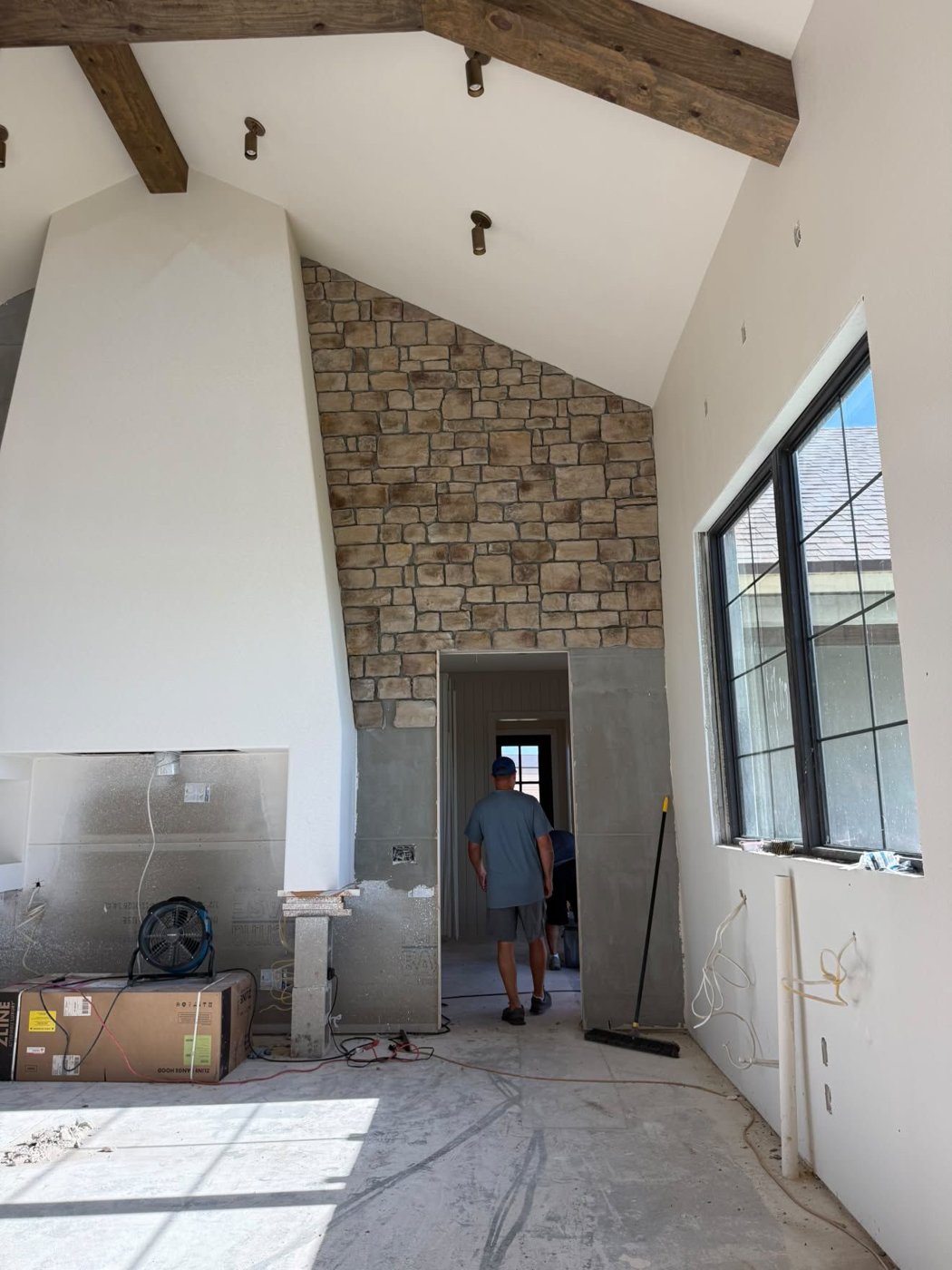 Scratch coat and partial Horizon Stone installation around a fireplace, showing the surface behind the stone