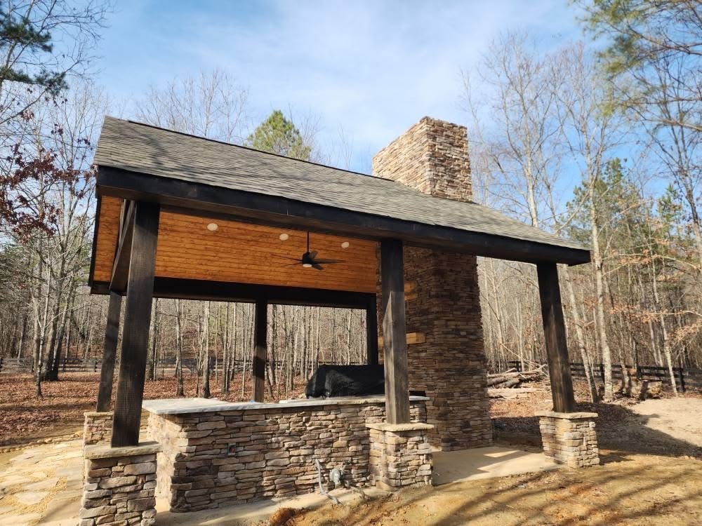 Ledgestone in Mossy Creek on an outdoor fireplace and kitchen surrounded by trees